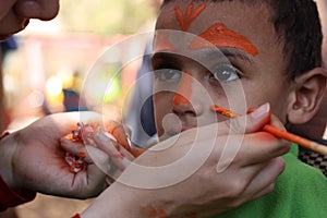 Cute Little boy having his face painted Kids having fun playing