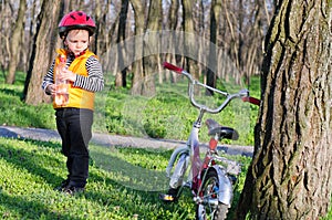 Cute little boy with his bike in woodland