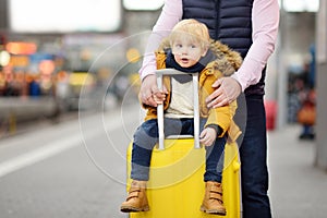 Cute little boy and his father waiting express train on railway station platform
