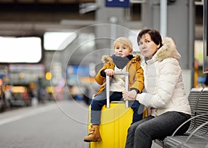 Cute little boy and his grandmother/mother waiting express train on railway station platform