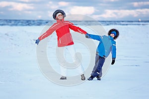 Cute little boy and his mother on icy beach