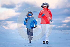 Cute little boy and his mother on icy beach