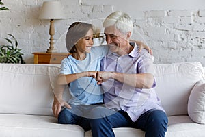 Cute little boy his older grandfather making fist bumping gesture