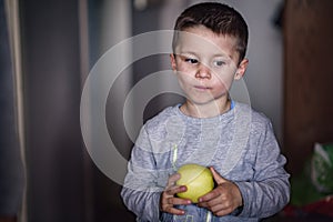 Cute little boy holding an apple