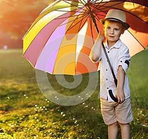 Cute, little boy holding a colorful umbrella