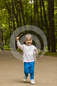 Cute little boy holding a large round lollipop on a stick. Joyful emotions. Sweets for small children. Summer outdoor activities.