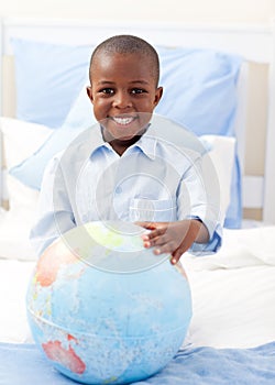 Cute little boy holding a terrestrial globe