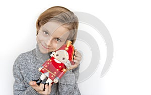 Cute little boy holding wooden toy of Nutcracker on white background with copy space