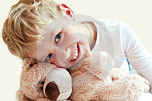 Cute little boy hugs his teddy bear.