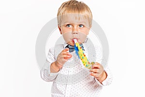 Cute little boy, jeans and shirt blowing in the birthday tune