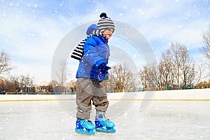 Cute little boy learning to skate in winter