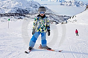 Cute little boy, learning to ski in Austrian ski resort