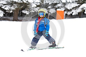 Cute little boy, learning to ski in Austrian ski resort