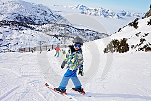 Cute little boy, learning to ski in Austrian ski resort