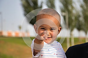 Cute little boy with little hair, in his father\'s arms is making different expressions while having his picture taken.