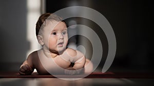 Cute little boy lying on his forearms on the floor.