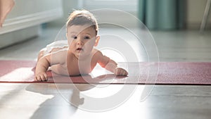 Cute little boy lying on his forearms on the floor.