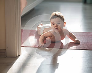 Cute little boy lying on his forearms on the floor.