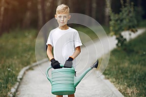 Cute little boy planting a tree on a park