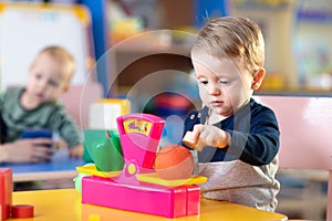 Cute little boy playing with abacus in nursery. Preschooler having fun with educational toy in daycare or creche. Smart