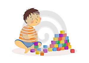 Cute little boy playing with blocks. Vector illustration. Summer activities. Children playing outside. Funny character