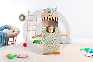 Cute little boy playing with cardboard dragon