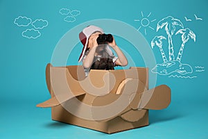 Cute little boy playing with cardboard plane and drawing of island