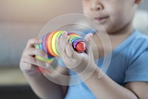 Cute little boy playing with colorful toys on floor at home. Evolution and paleontology game for young kid