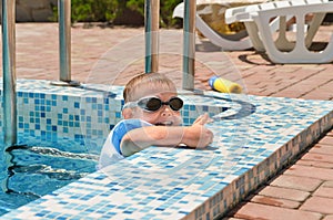 Cute little boy playing at the edge of a pool