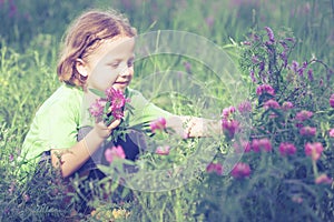 Cute little boy playing with flowers in park