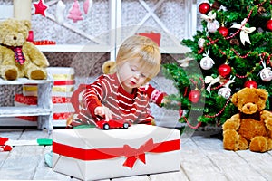 Cute little boy playing with his red toy car