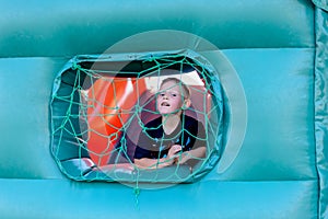 Cute little boy playing in a jumping castle