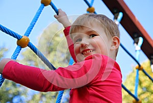 Cute little boy playing on monkey bars