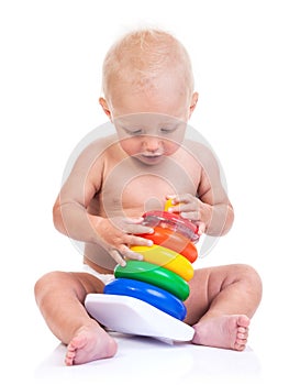 Cute little boy playing with pyramid toy on white