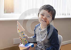 Cute little boy playing with spaceship, Happy child holding toy rocket, Portrait of funny kid, Toddler creativity, Concept for art