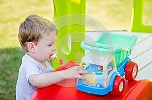 Cute little boy plays with toy car at park