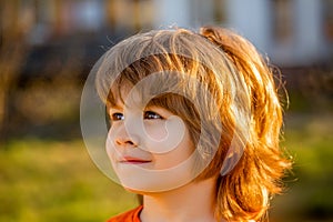 Cute little boy portrait closeup. Blonde child. Portrait of happy kid outdoors. Little boy walks on outdoors, spring