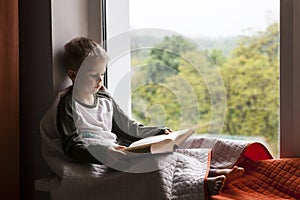 Cute little boy reading book