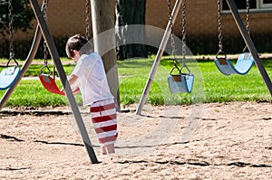 Cute little boy ready to saddle up on the swing