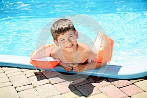 Cute little boy resting in swimming pool