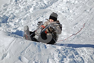 Cute little boy riding motorcyle in the snow outdoors.