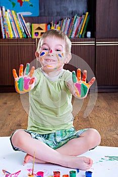 Cute little boy showing his colorful palms