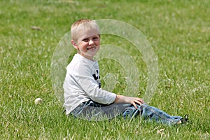 Cute little boy sitting in the grass