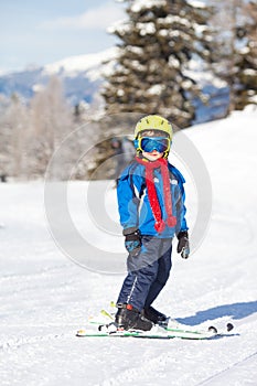 Cute little boy, skiing happily in Austrian ski resort in the mo