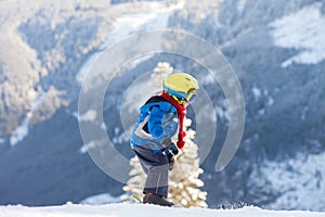 Cute little boy, skiing happily in Austrian ski resort in the mo