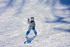 Cute little boy, skiing happily in Austrian ski resort in the mo