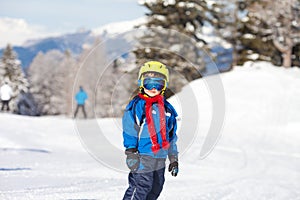 Cute little boy, skiing happily in Austrian ski resort in the mo