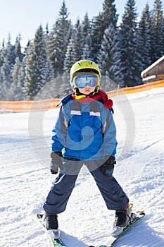 Cute little boy, skiing happily in Austrian ski resort in the mo