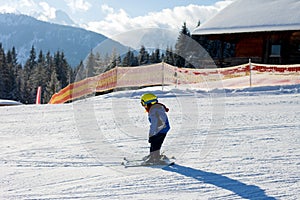 Cute little boy, skiing happily in Austrian ski resort in the mountains