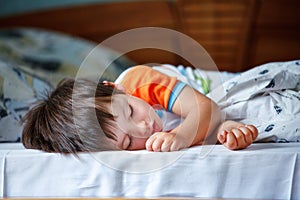 Cute little boy sleeping in a bed